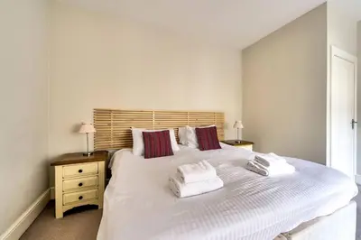 a bedroom with a large white bed with towels on it at JOIVY Bright 1 bed flat, close to Princess Street in Edinburgh