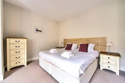 a bedroom with a large white bed and two night stands at JOIVY Bright 1 bed flat, close to Princess Street in Edinburgh