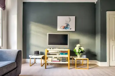 a living room with a television on a wall at JOIVY Bright 1 bed flat, close to Princess Street in Edinburgh