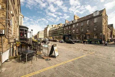 a city street with buildings and a sign on the street at JOIVY Stylish Home in New Town in Edinburgh