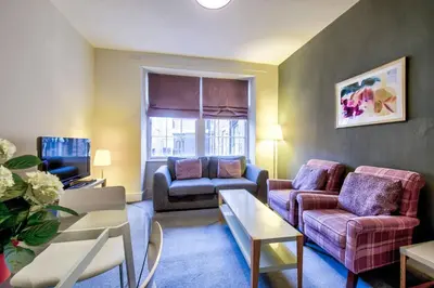 a living room with a couch and a table at JOIVY Stylish Home in New Town in Edinburgh