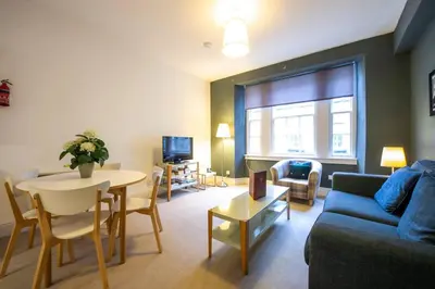 a living room with a couch and a table at JOIVY Charming Apt close to City Centre in Edinburgh