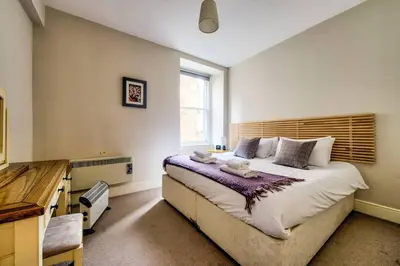 a bedroom with a large bed and a window at JOIVY Amazing Location! Lovely Rose St Apt in New Town in Edinburgh