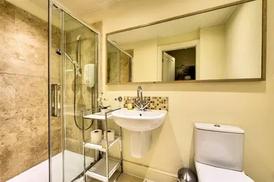 a bathroom with a toilet and a sink and a shower at JOIVY Amazing Location! Lovely Rose St Apt in New Town in Edinburgh