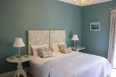 a blue bedroom with a bed with two tables at Balmule House in Dunfermline