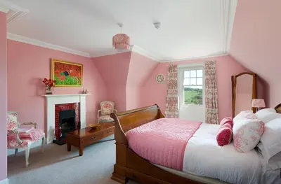 a pink bedroom with a bed and a fireplace at Balmule House in Dunfermline