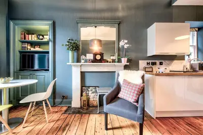 a kitchen with a table and a chair and a counter at GuestReady - Stylish 2BR in Heart of Tollcross in Edinburgh
