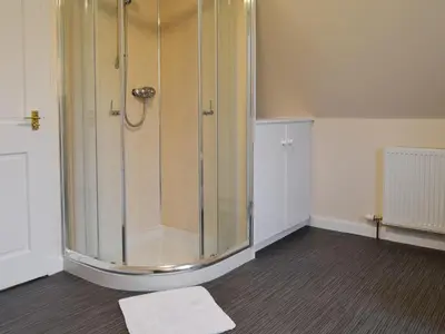 a shower with a glass enclosure in a room at Liftingstane Farmhouse in Closeburn