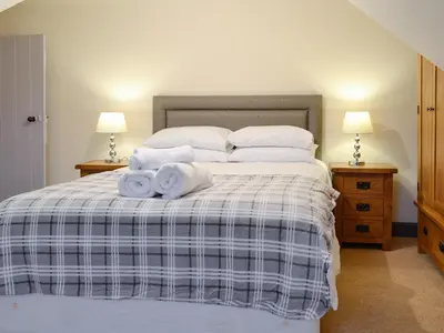 a bedroom with a bed with towels on it at Liftingstane Farmhouse in Closeburn