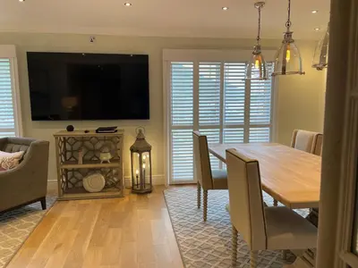 a dining room with a table and a television at Stormfront Luxury Hideaway Glencoe Ballachulish Highlands Near Fortwilliam in Glencoe