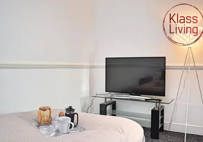 a living room with a tv and a table with a bed at Whifflet Apartment by Klass Living Coatbridge in Coatbridge