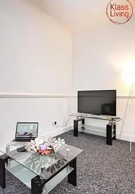 a living room with a tv and a table at Whifflet Apartment by Klass Living Coatbridge in Coatbridge