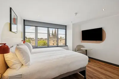 a bedroom with a large bed and a large window at Garner Hotel Edinburgh - Haymarket by IHG in Edinburgh