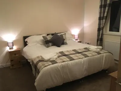 a bed in a room with two lamps on a table at 1 Balnakeil, Kirk Road in Oban