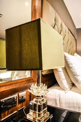 a bedroom with a bed with a lamp on a table at Dalziel Park Hotel in Motherwell