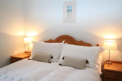 a white bed with two pillows and two lamps at The Colonsay Hotel in Isle of Colonsay