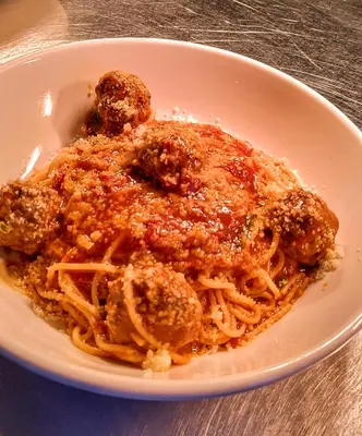 a white bowl of spaghetti with meatballs and sauce at The Colonsay Hotel in Isle of Colonsay