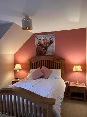 a bedroom with a bed with a painting of a bull at Shenavallie Farm in Benderloch