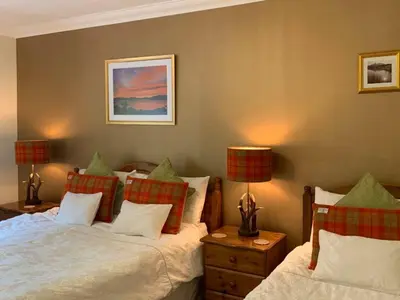 a bedroom with two beds and two lamps at Ardno House B & B in Glencoe