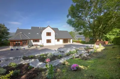 a large white house with a yard with flowers at Ardno House B & B in Glencoe