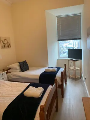 a room with two beds and a tv and a window at Home with a view in Moffat