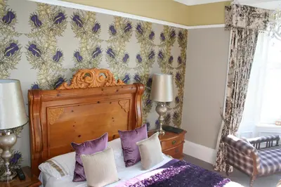 a bedroom with a bed with purple pillows at Altavona House in Oban