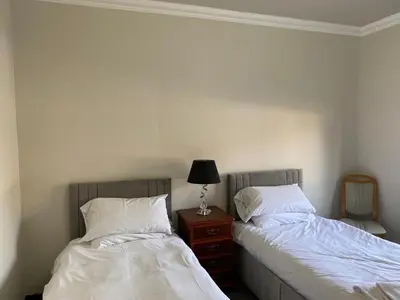 two beds sitting next to each other in a bedroom at Welltrees Apartments 10 Dailly Road in Maybole