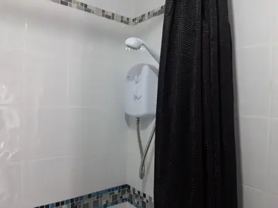a shower in a bathroom with a black shower curtain at Hardgate Gardens in Glasgow