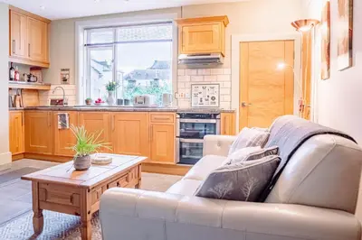 a living room with a couch and a table at Cottage Apartment in Dunblane