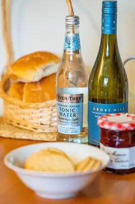 a table with two bottles of wine and a bowl of bread at Cottage Apartment in Dunblane