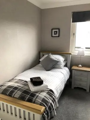 a small bedroom with a bed and a window at Old Police House Causewayhead Stirling in Stirling