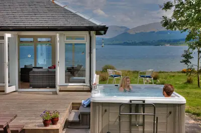 a man and woman in a hot tub on a patio at Seabank House in Oban