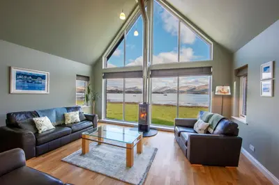 a living room with two couches and a table at Seabank House in Oban