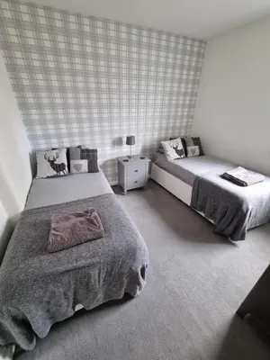 a bedroom with two beds and a night stand at Bespoke Tours Scotland Accommodation @ Morrison Street in Edinburgh