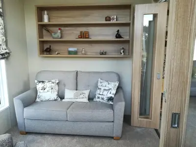 a gray couch with pillows sitting in a living room at Brightwater Lodge in Dunning