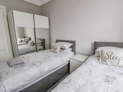 a bedroom with two beds and a large mirror at Ayr Beach View Apartment in Ayr