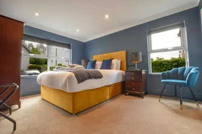 a bedroom with a large bed and a blue wall at Raniven in Oban