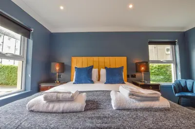 a bedroom with a large bed with blue walls at Raniven in Oban