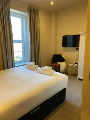 a hotel room with a bed and a tv at Raniven in Oban
