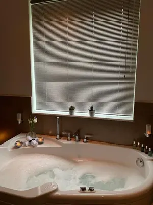 a large bath tub in a bathroom with a window at Invercreran Lodge Luxury Bed & Breakfast in Appin