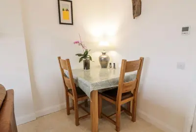 a dining room table with chairs and a vase with flowers at Sealladh in Port Appin