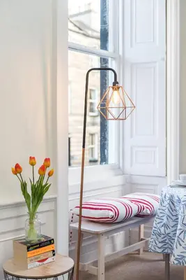 a lamp sitting on a table next to a window at Charming, Central & Spacious Georgian 3 bed APT in Edinburgh