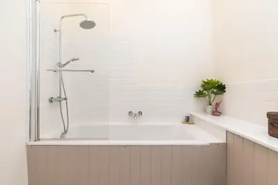 a white bathroom with a tub and a shower at Charming, Central & Spacious Georgian 3 bed APT in Edinburgh