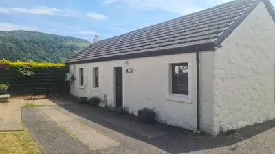 a white cottage with a window and a roof at Hawthorn Self Catering Cottages in Benderloch