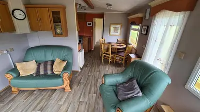 a living room with two chairs and a table at Hawthorn Self Catering Cottages in Benderloch