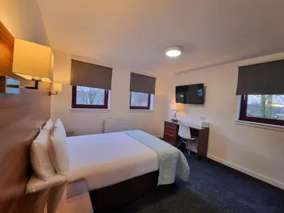 a hotel room with a bed and a desk at Premier Lodge in Falkirk