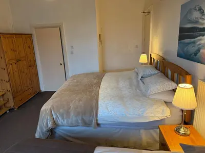 a bedroom with a large bed and a table with a lamp at Glades House in Glasgow