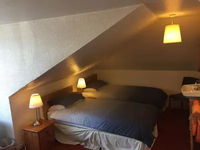 a bedroom with two beds and a sink and two lamps at Glades House in Glasgow