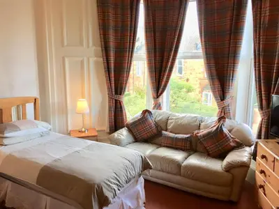 a living room with a couch and a window at Glades House in Glasgow