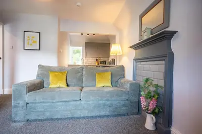 a blue couch with two yellow pillows in a living room at One Oban in Oban